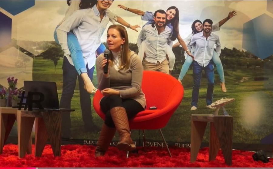 Dany conversa sentada en un sillón rojo durante una grabación en un foro.